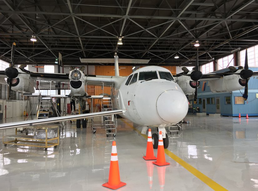 Gray epoxy floors in hanger with airplane ontop